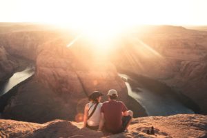 couple sitting on mountain watching sun rise